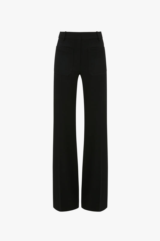 A pair of black trousers viewed from the back, featuring belt loops, two back pockets, and straight legs. Designed with subtle nods to 70s style references, these Victoria Beckham Alina Tailored Trouser In Black add a touch of retro sophistication.