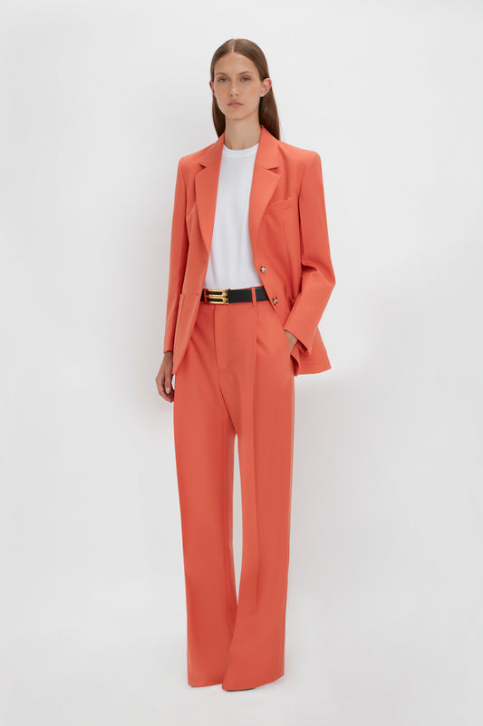 Woman in a stylish Victoria Beckham Patch Pocket Jacket In Papaya with a white relaxed fit T-shirt, standing against a plain white background.