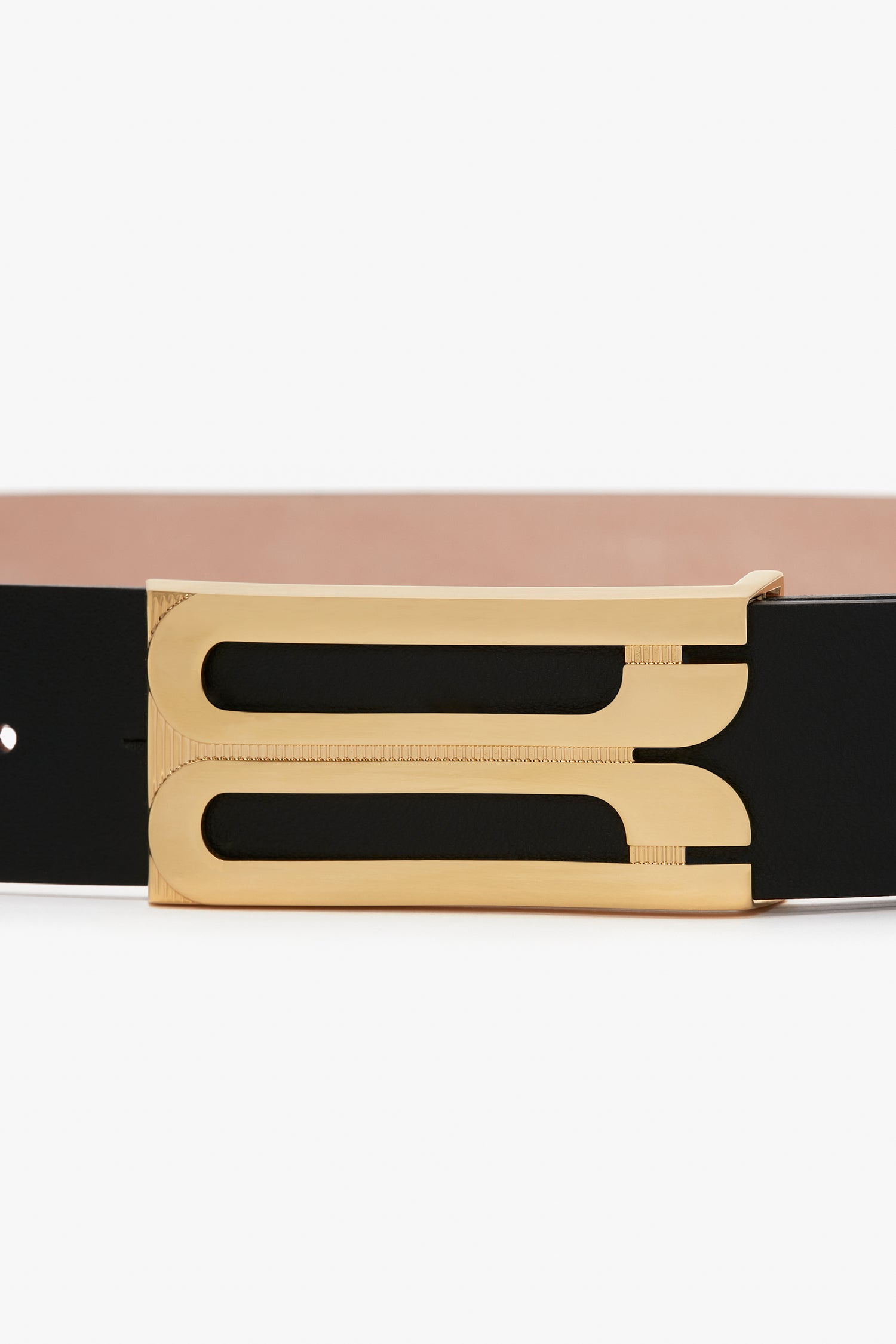 A close-up of an Exclusive Jumbo Frame Belt In Navy Leather by Victoria Beckham, showcasing its black smooth calf leather strap and gold hardware buckle with a sleek, modern design.