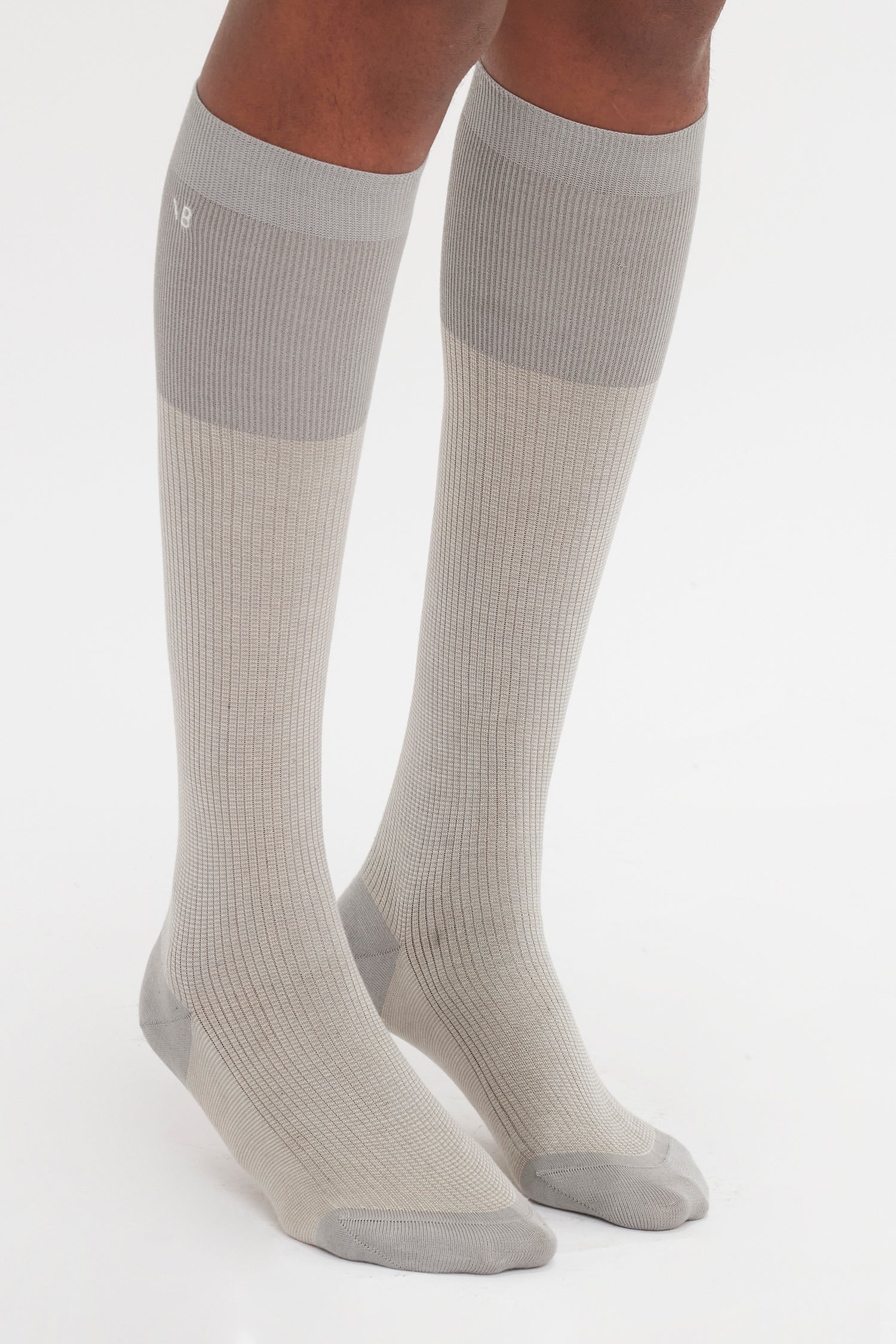 Person wearing light gray Superfine Rib Socks In Lunar Grey by Victoria Beckham, an elevated wardrobe essential made from 100% cotton.