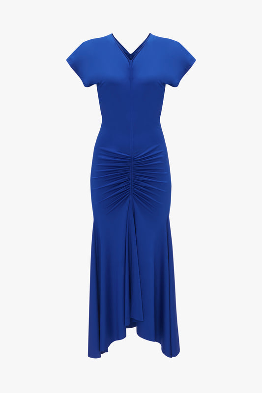 Victoria Beckham's sleeveless rouched jersey dress in royal blue, with a v-neckline and gathered detailing at the waist, displayed on a plain white background.