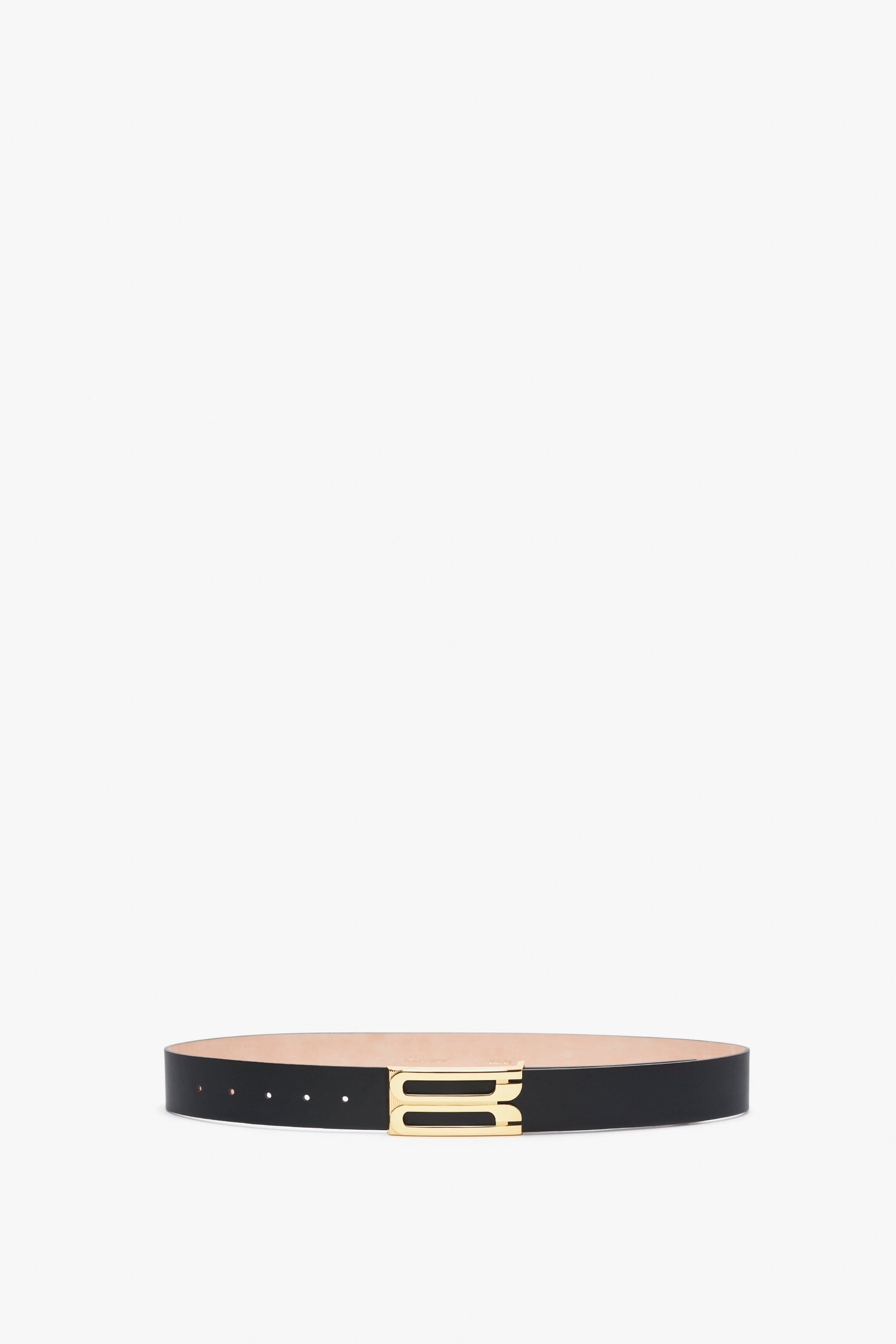 A sleek Exclusive Jumbo Frame Belt In Navy Leather by Victoria Beckham crafted from smooth calf leather with elegant gold hardware, laid out on a pristine white background.