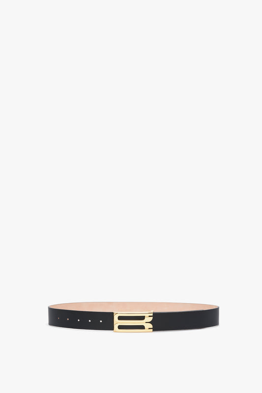 A sleek Exclusive Jumbo Frame Belt In Navy Leather by Victoria Beckham crafted from smooth calf leather with elegant gold hardware, laid out on a pristine white background.