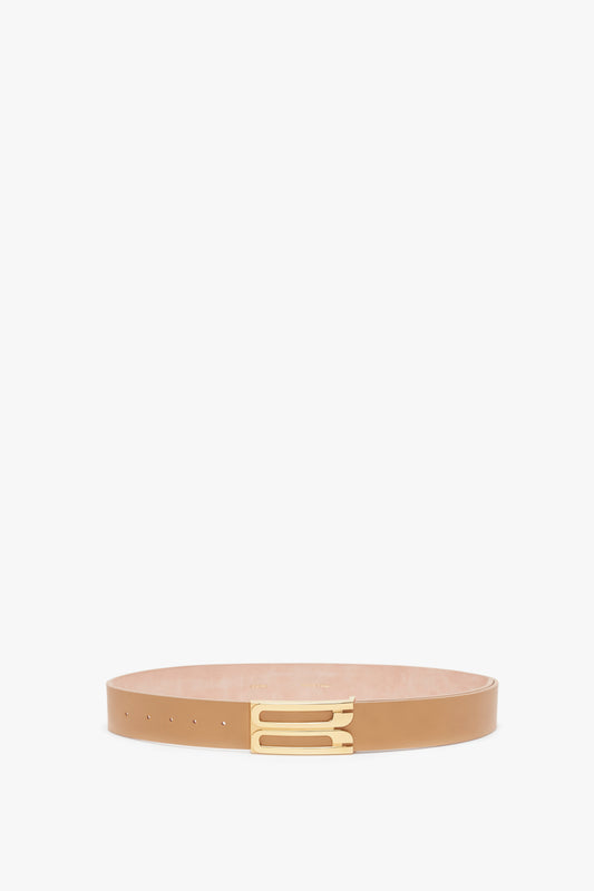 A Jumbo Frame Belt in Camel Leather with a gold buckle, displayed horizontally on a white background by Victoria Beckham.