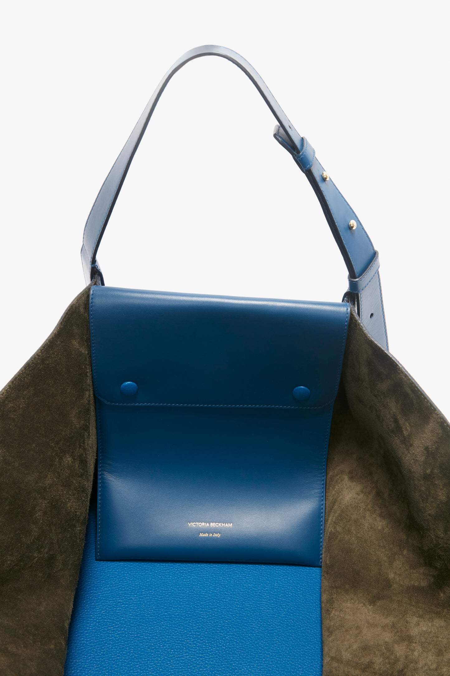 Blue and olive green grained leather W11 Medium Tote Bag In Vibrant Blue Leather with an adjustable blue strap and silver hardware. The interior flap has "Victoria Beckham Made in Italy" imprinted in white text.