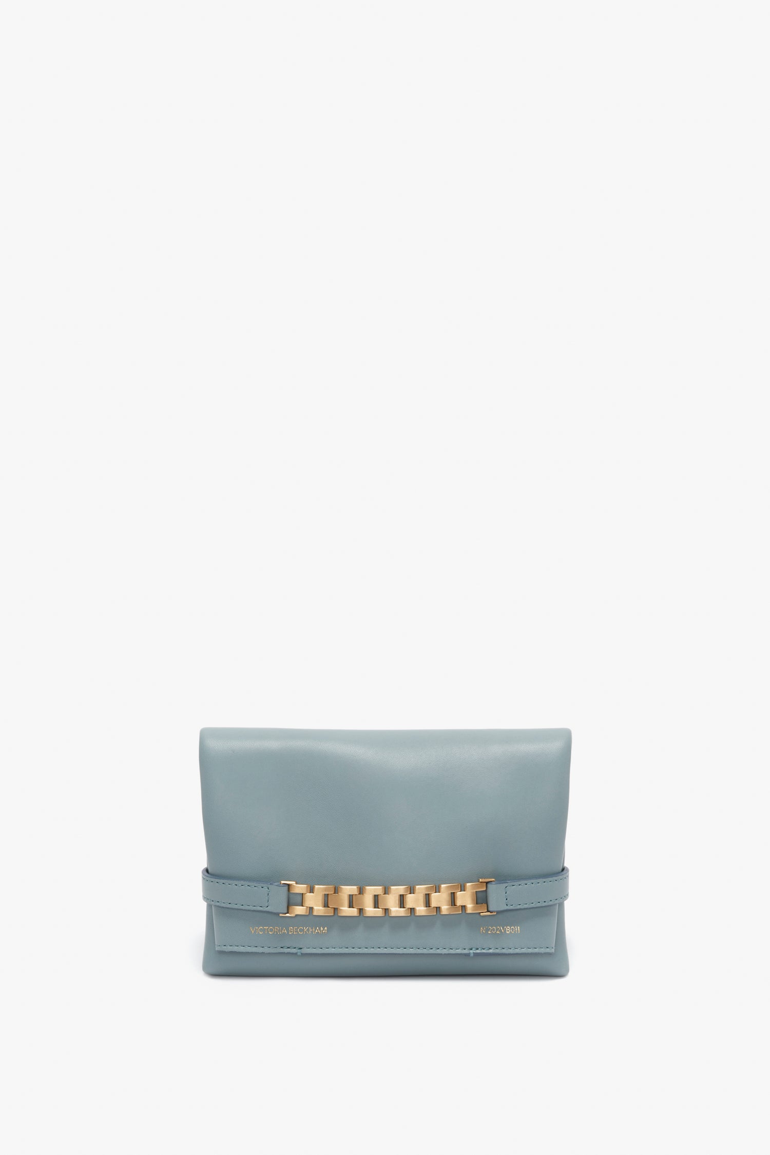 A Victoria Beckham Mini Chain Pouch Bag With Long Strap In Ice Leather with a gold-tone chain detail on the front and embossed text in gold on the lower part. This stylish shoulder bag is perfect for adding a touch of elegance to any outfit.