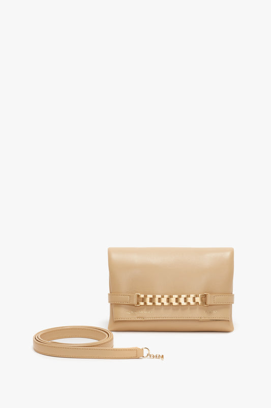 Victoria Beckham's Mini Pouch With Long Strap In Sesame Leather, with a shoulder strap and decorative front chain detail, displayed against a white background.