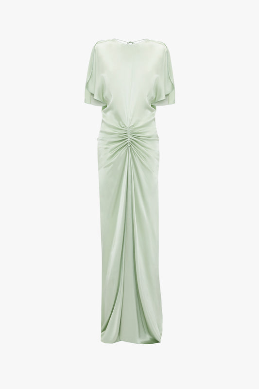 Exclusive floor-length gathered dress in jade by Victoria Beckham featuring short sleeves, a boat neckline, and a cinched gathered waist, displayed against a white background.
