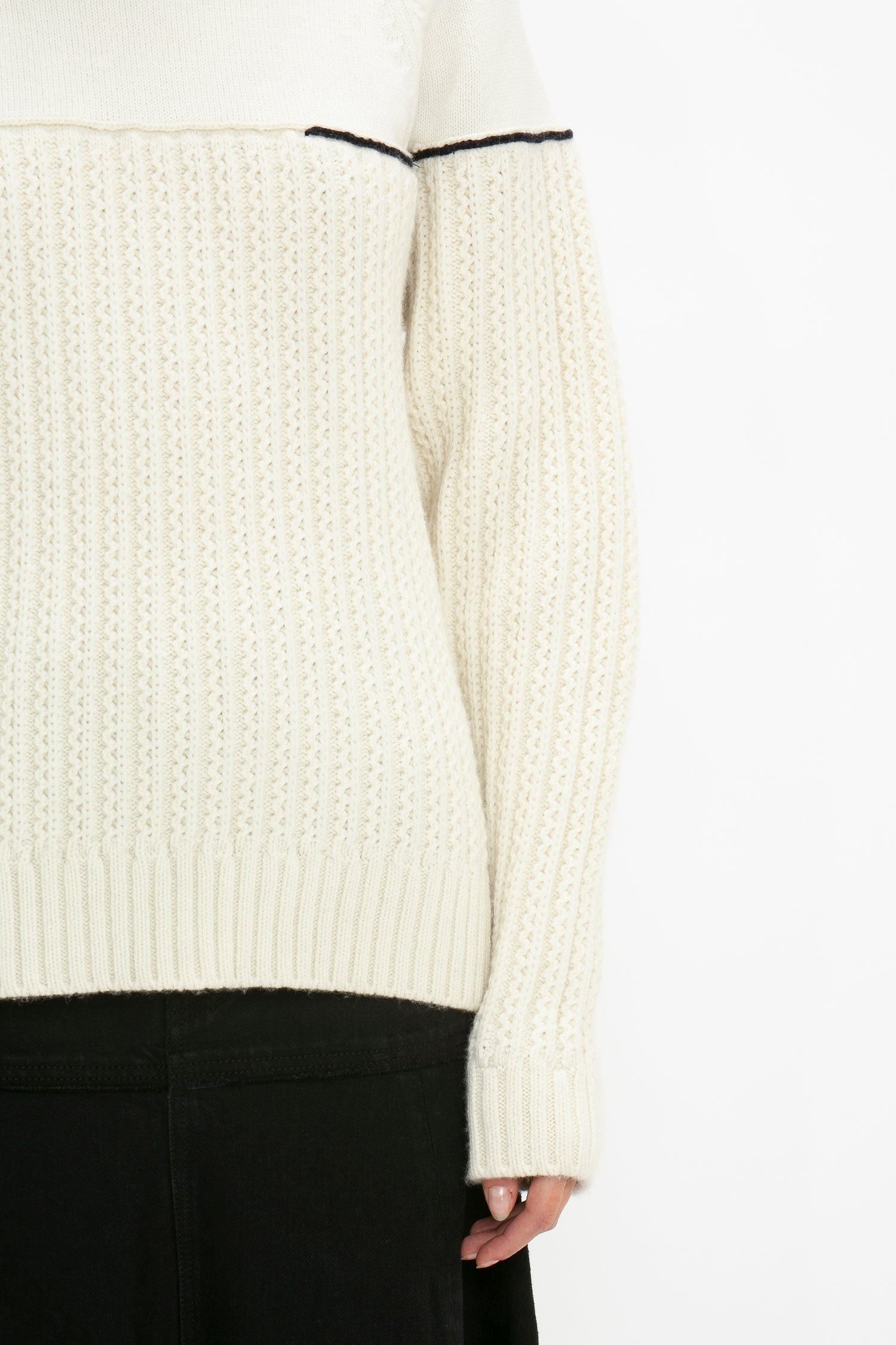 A close-up of a person wearing a Collar Detail Jumper In Natural by Victoria Beckham, paired with a black skirt.