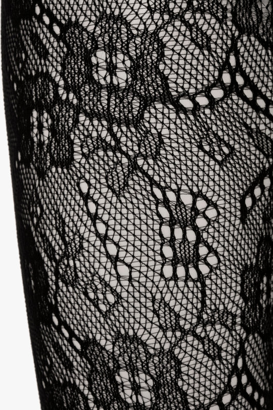 Close-up of black Victoria Beckham Monogram Lace Tights featuring intricate floral patterns and seamless, sag-free construction.