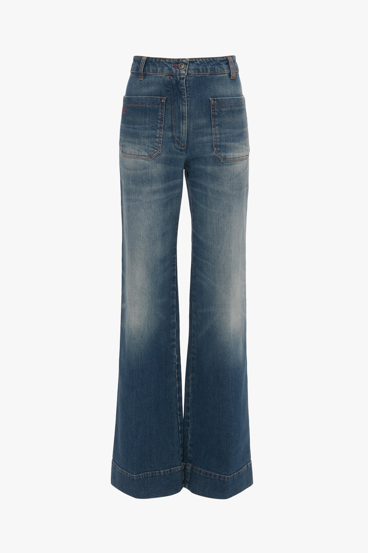 Alina Jean In Heavy Vintage Indigo Wash blue denim wide-leg jeans with front button and zipper, displayed on a white background by Victoria Beckham.