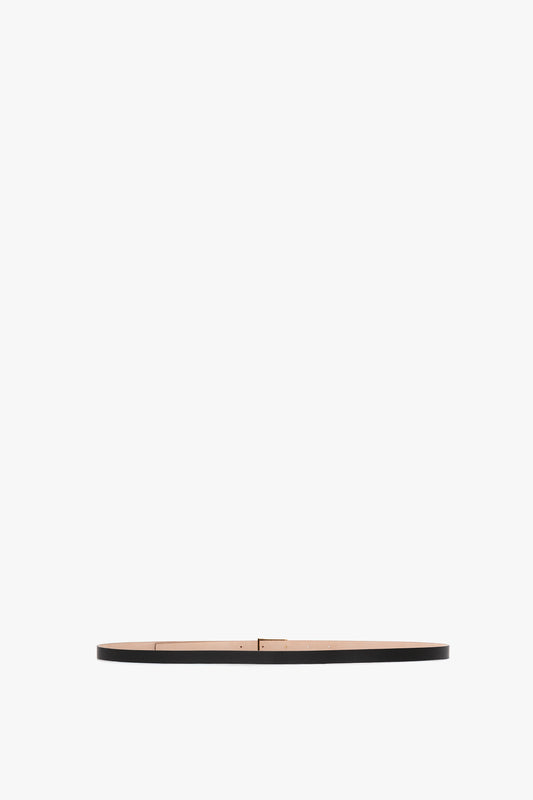 A slim, black calf leather Exclusive Micro Frame belt by Victoria Beckham with a small, rectangular gold buckle, centered on a plain white background.