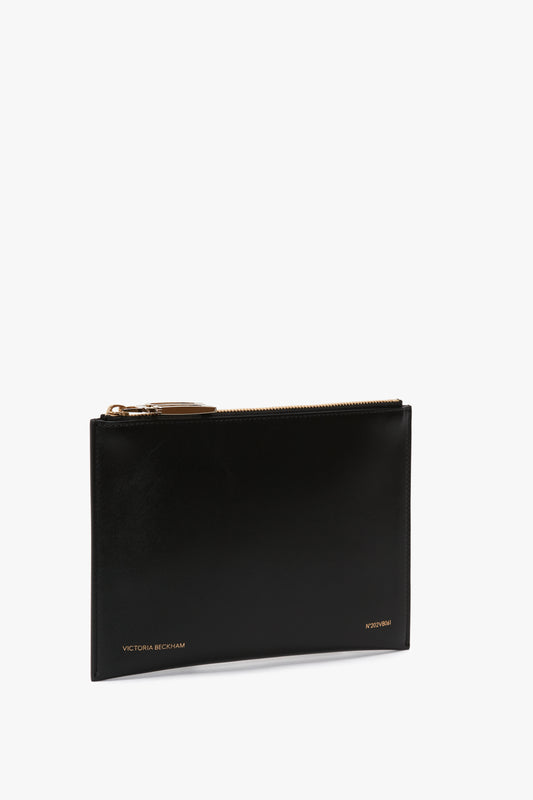 A black Victoria Beckham B Frame Pochette in black leather with gold-tone zip closure, photographed against a white background.