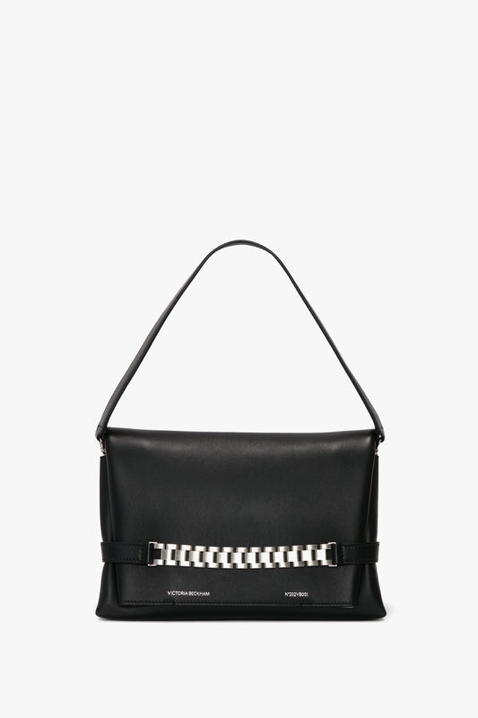 A Chain Pouch Bag with Brushed Silver Chain In Black Leather by Victoria Beckham, featuring a single handle and a brushed silver chain detail on the front, and a detachable strap for versatile styling.