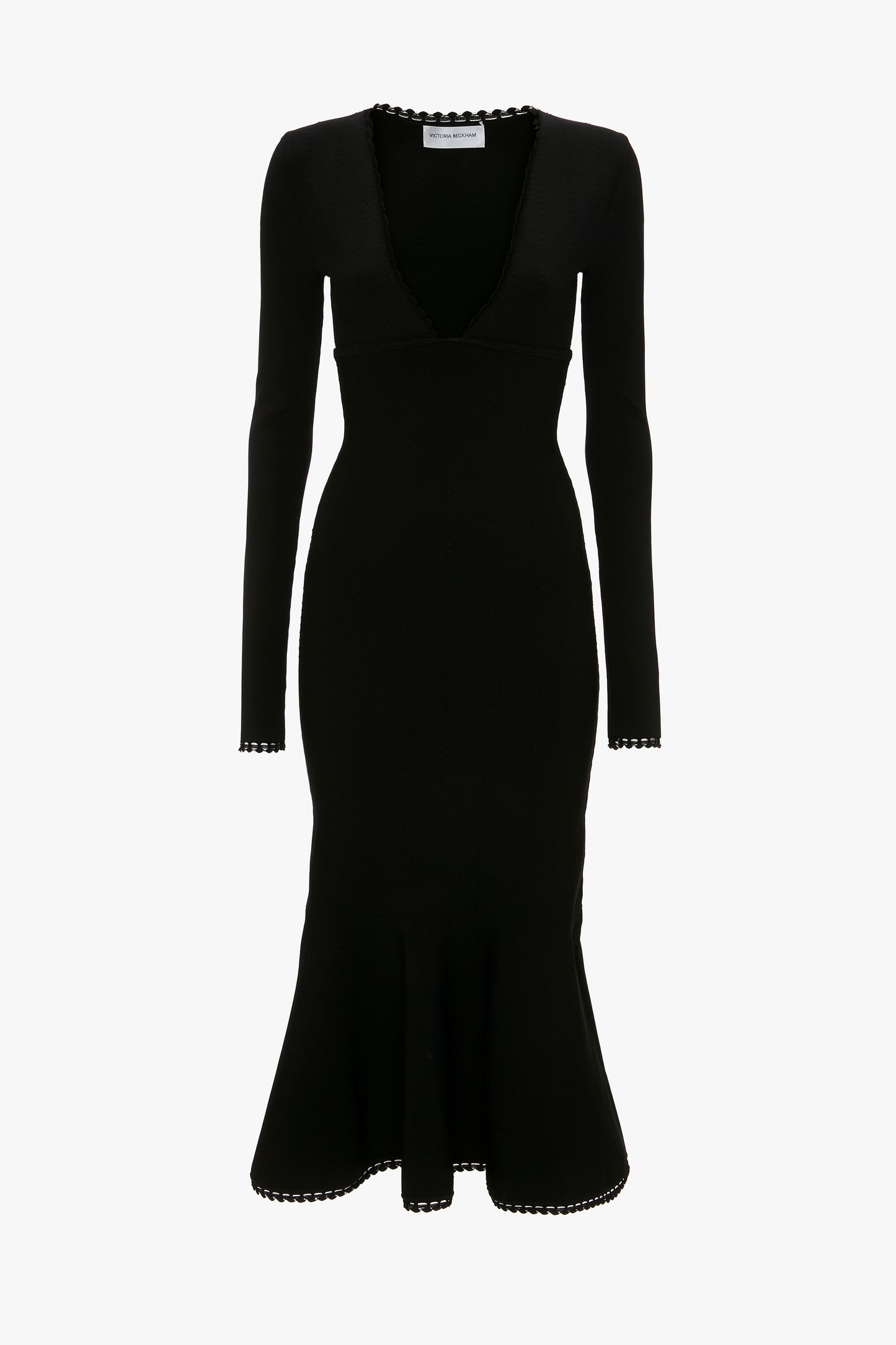 A Victoria Beckham VB Body Long Sleeve V Neck Dress In Black with a mid-length hem that features scalloped edges on the cuffs, hem, and plunging V-neck.