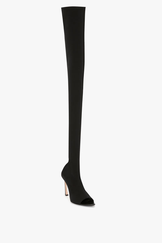 Black thigh-high boot with a sculptural heel and peep toe, displayed against a white background.
Product: Victoria Beckham Peep Toe Stretch Jersey Boot In Black