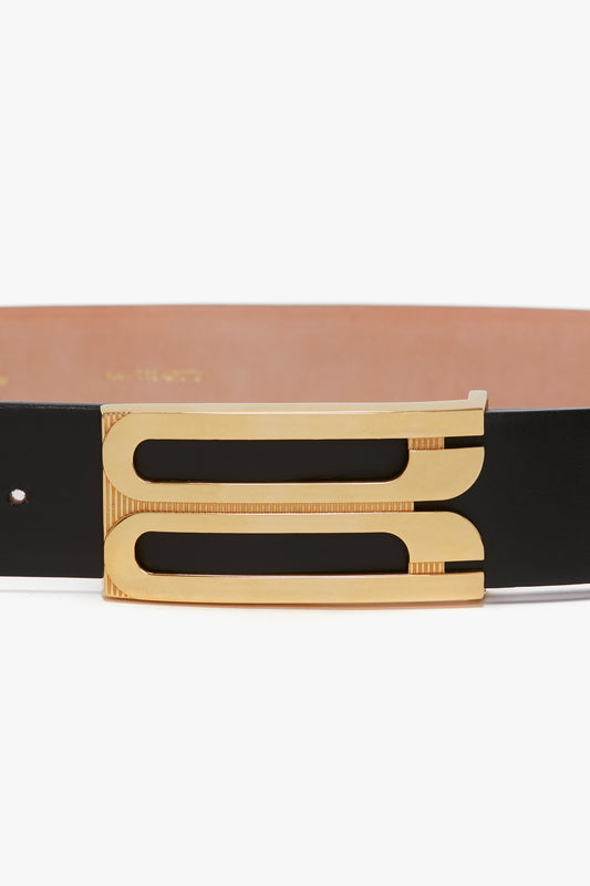 Close-up of a Victoria Beckham Exclusive Jumbo Frame Belt In Black Leather with gold hardware, photographed against a white background.