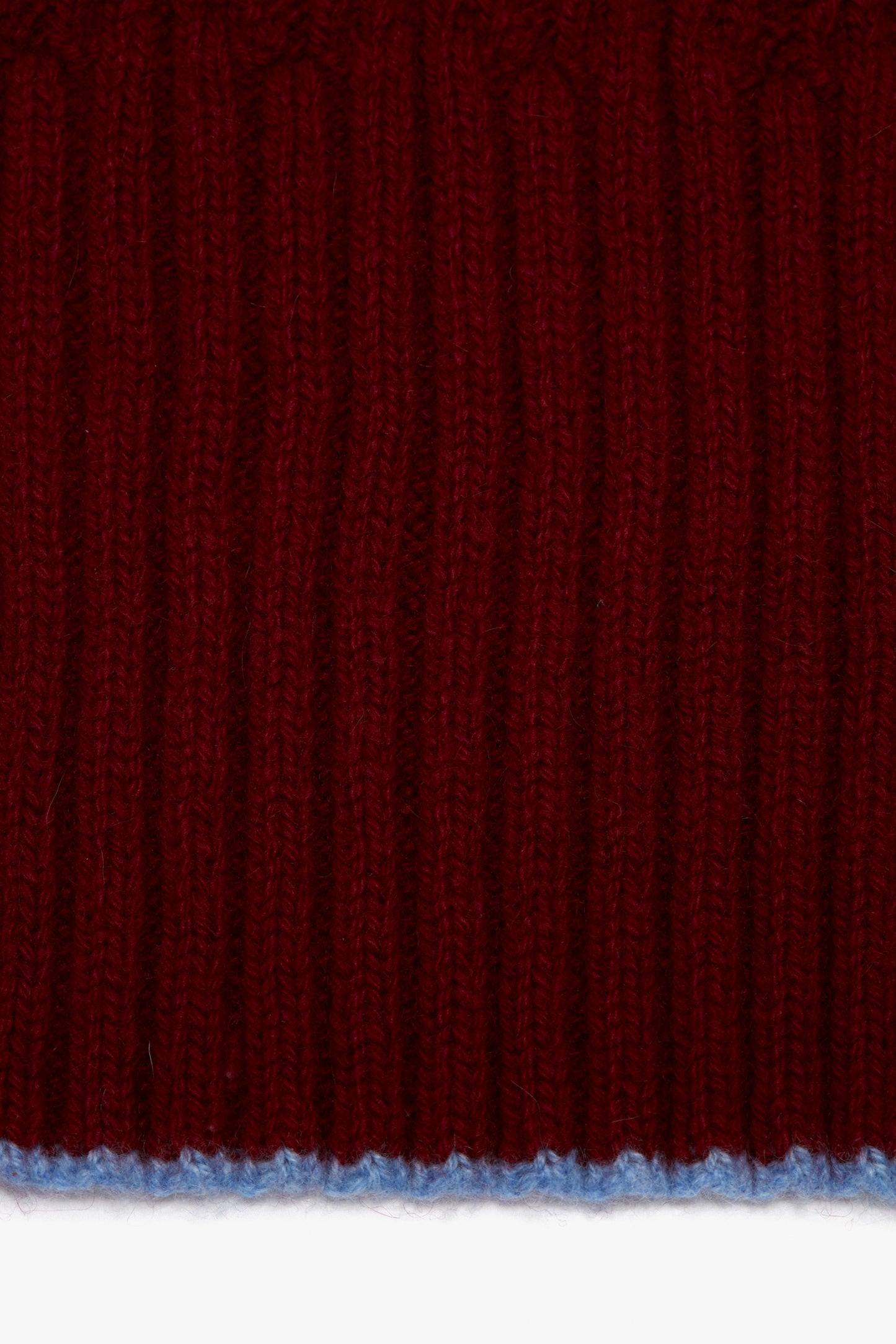 A close up of a Victoria Beckham Exclusive Logo Patch Scarf in Burgundy knitted fabric.