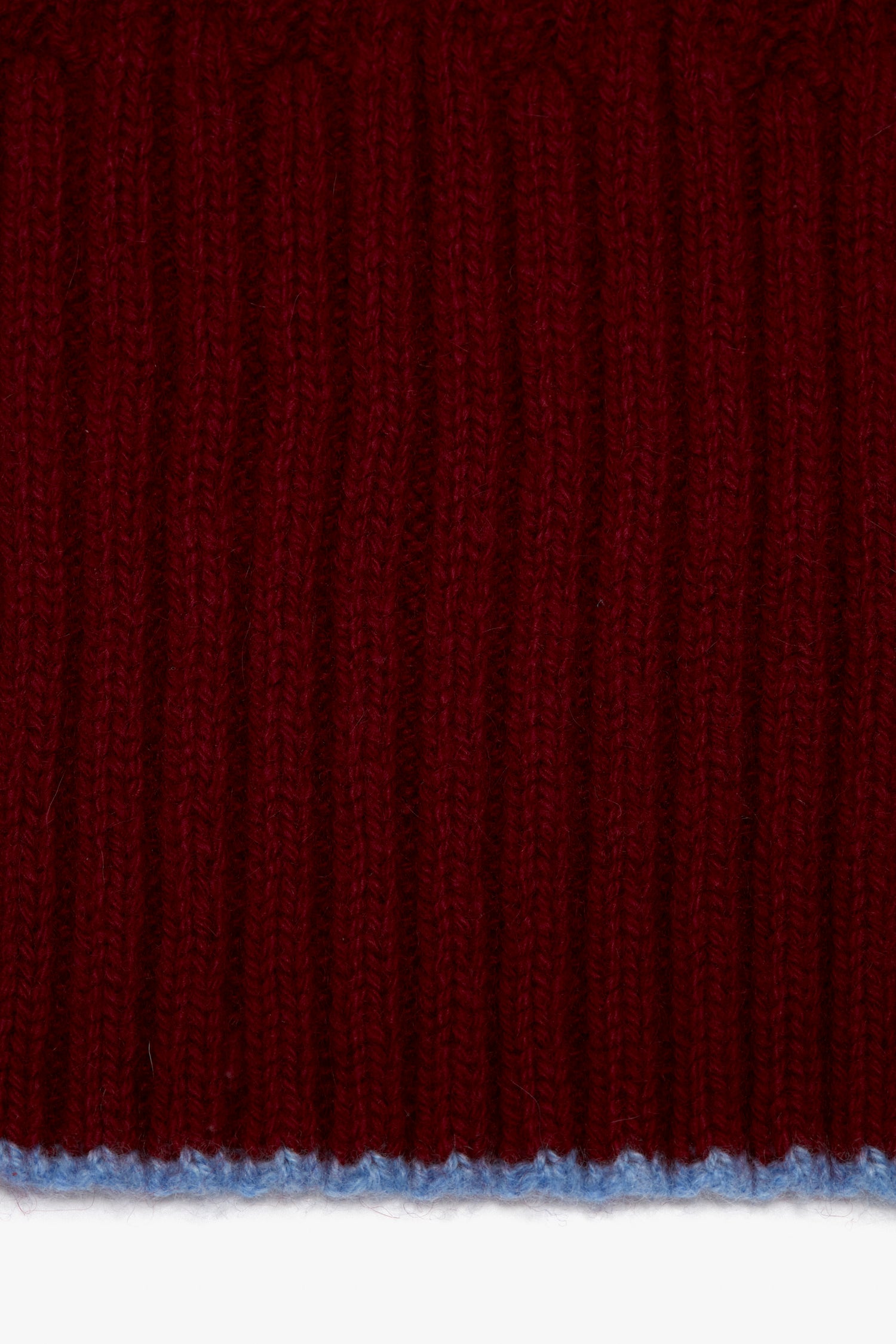 A close up of a Victoria Beckham Exclusive Logo Patch Scarf in Burgundy knitted fabric.