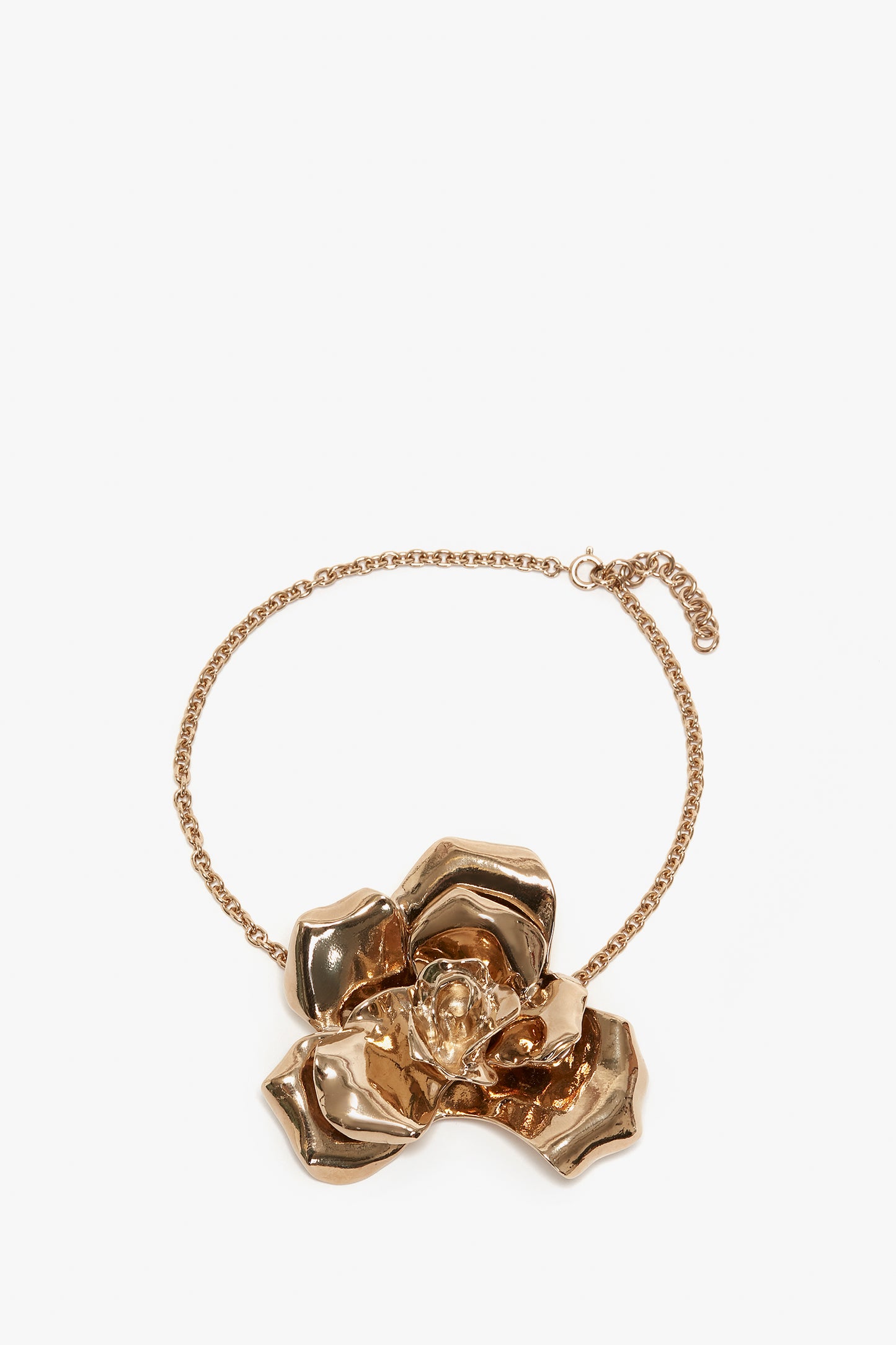 An Exclusive Flower Necklace In Gold by Victoria Beckham featuring a large, detailed gold flower with a small gemstone at its center, making it a stunning statement accessory.