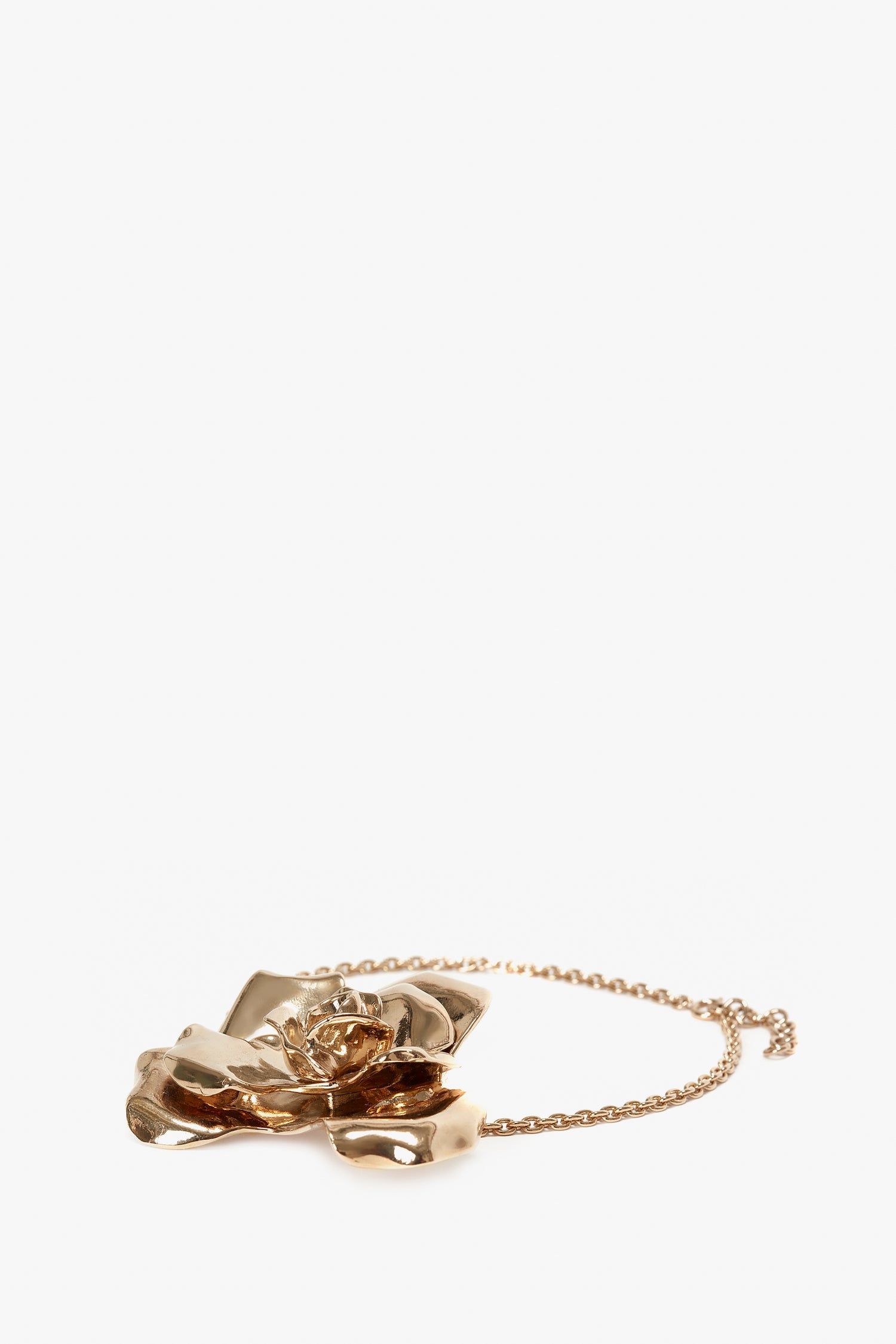 A Victoria Beckham Exclusive Flower Necklace In Gold featuring a large, intricately designed floral pendant on a delicate chain—perfect as a statement accessory.