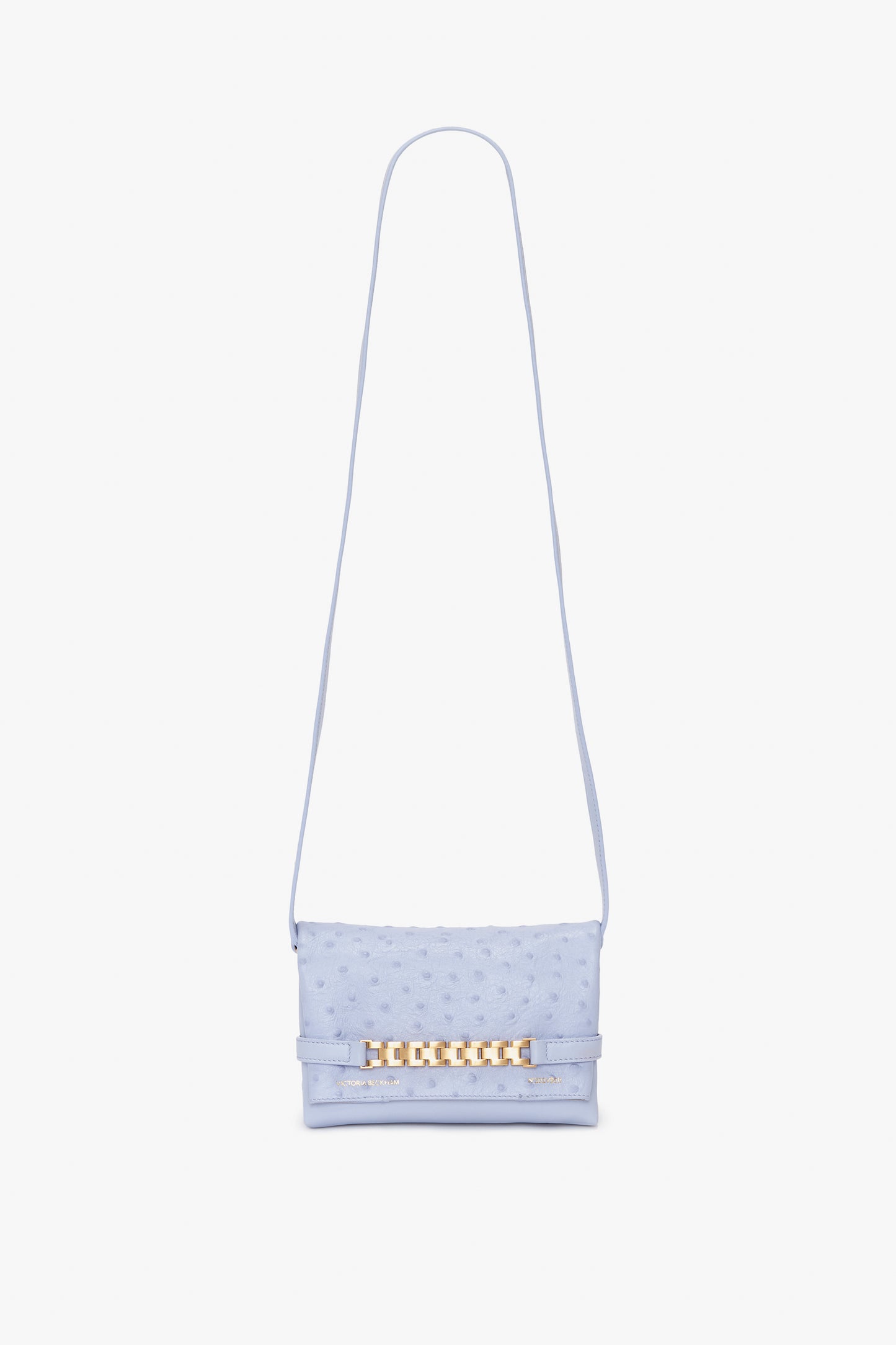 A light blue textured Mini Chain Pouch With Long Strap In Frost Ostrich-Effect Leather by Victoria Beckham, featuring a long strap and a gold-tone decorative clasp on the front.