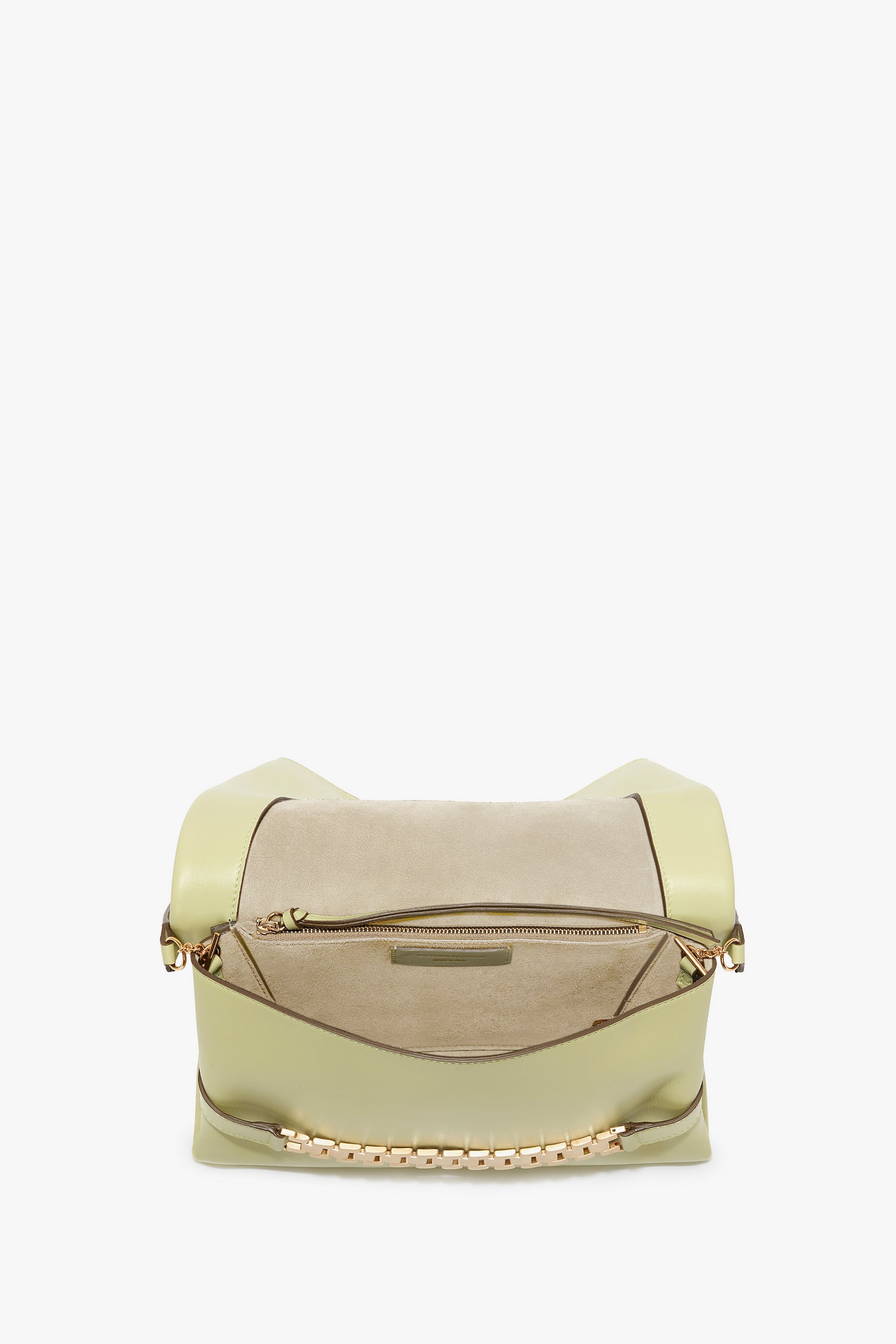 A beige and light green leather handbag in an avocado shade featuring a zipper pocket and gold chain accents on the handles, reminiscent of Victoria's vintage watch straps, viewed from the top. The Chain Pouch Bag With Strap In Avocado Leather by Victoria Beckham.