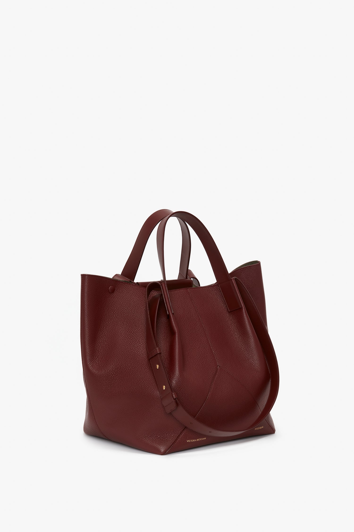 A Victoria Beckham Medium Tote In Burgundy Leather with two handles, standing upright against a plain white background.