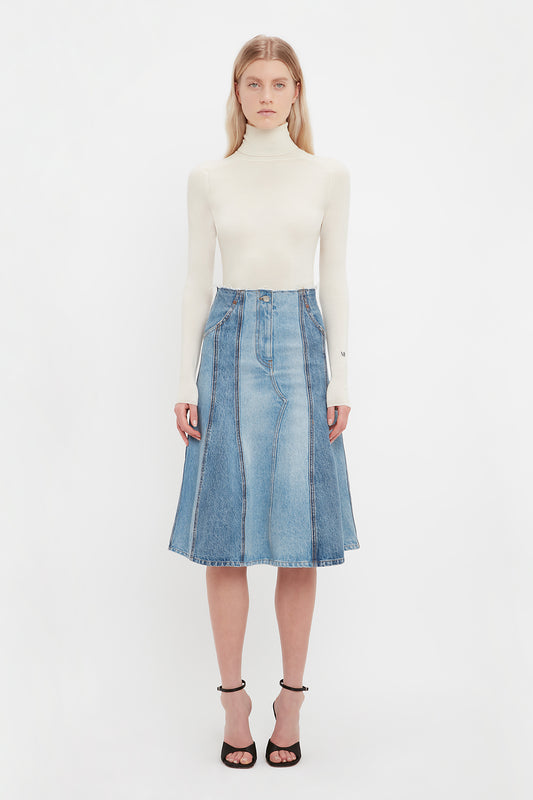 Modeal wearing the denim midi skirt from luxury fashion house Victoria Beckham. This long denim skirt has vertial patchwork detailing and sits at the waist. 
