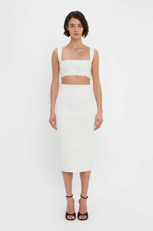 A woman wearing a white strap VB Body Strap Bandeau Top in White and matching VB Body Fitted Midi Skirt stands facing forward against a plain white background.