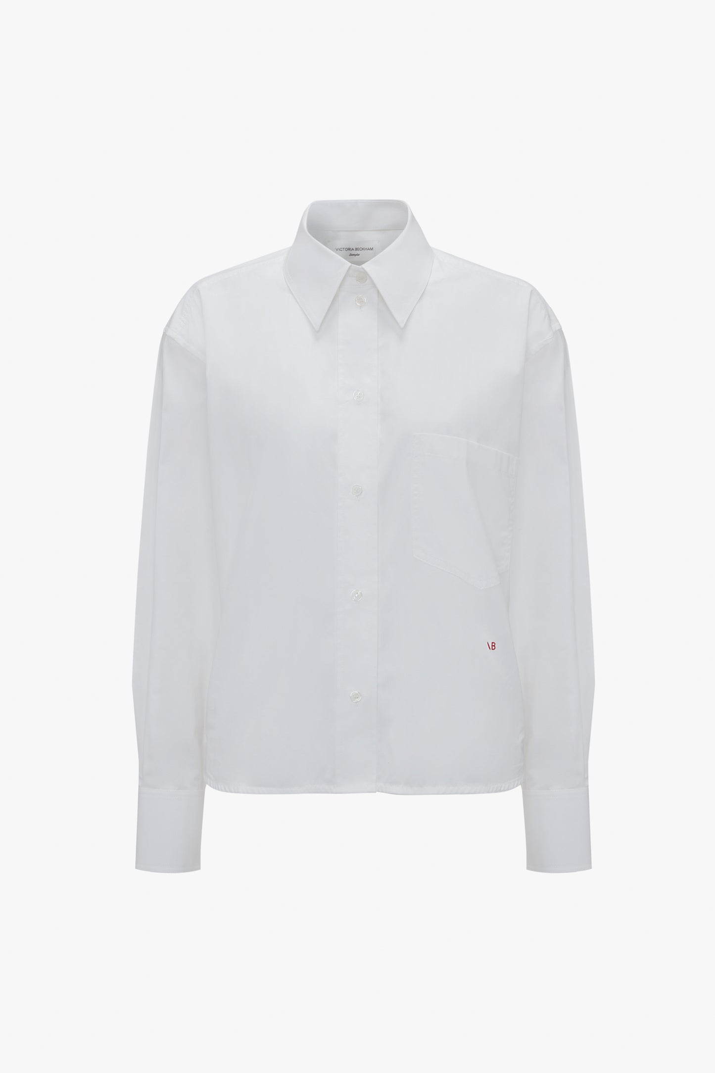 A Victoria Beckham Cropped Long Sleeve Shirt In White with a collar and a left chest pocket, displayed against a plain white background.