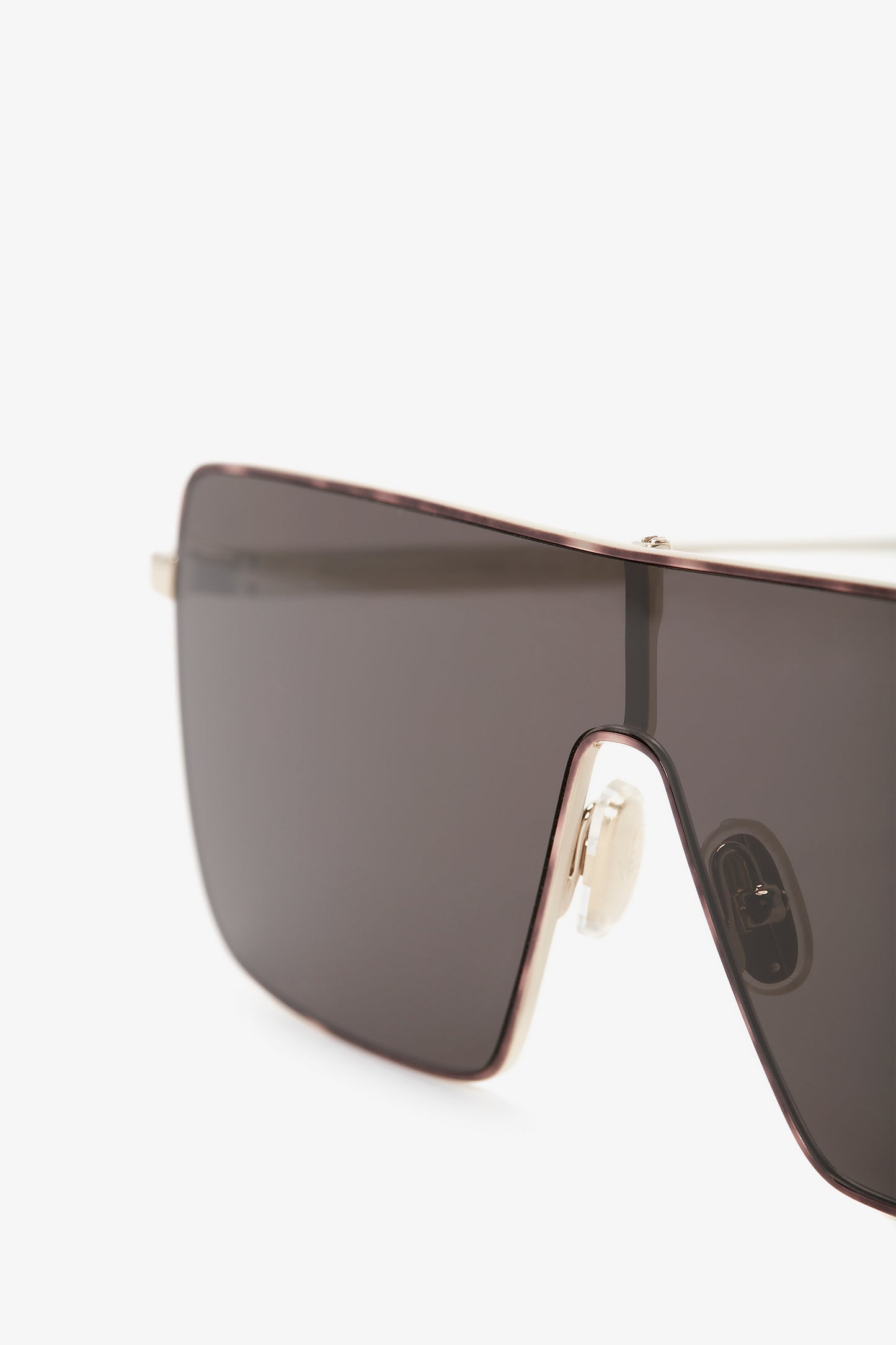 Close-up of Rectangular Visor In Gold-Smoke with dark tinted lenses and a sleek, metal frame, featuring the Victoria Beckham logo.