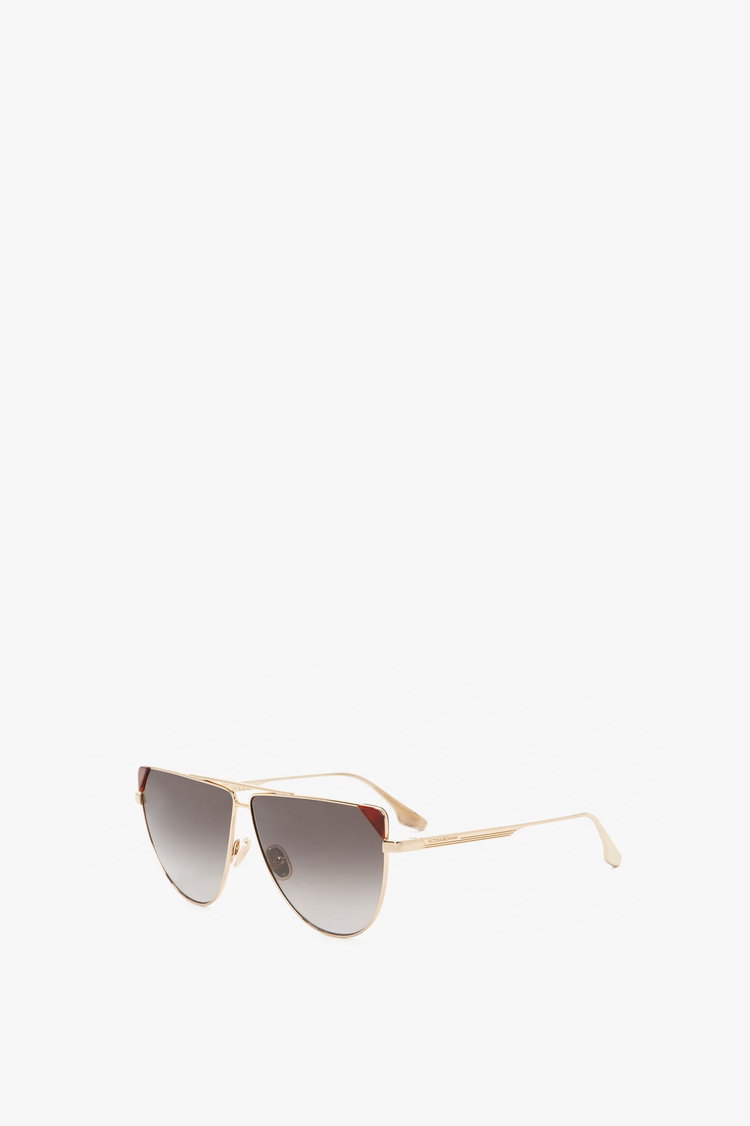 A pair of Victoria Beckham V-Line Aviator In Gold Blonde Havana sunglasses featuring gold metal frames and caramel gradient lenses on a white background.