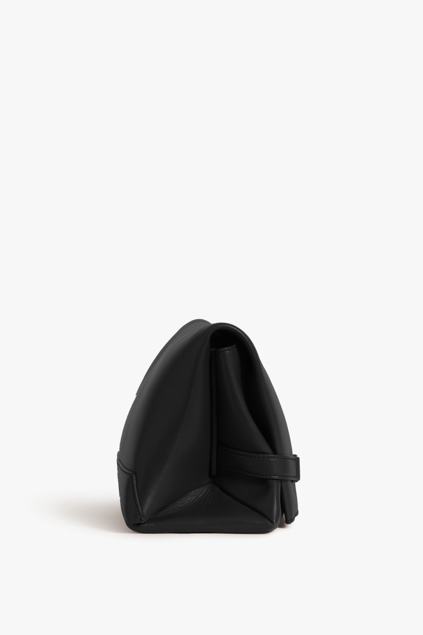 Side view of a black Chain Pouch Bag In Black Leather with minimalist design, featuring gold-tone hardware, showing a flat bottom and a wide open main compartment with strap closure. The background is plain white. By Victoria Beckham.
