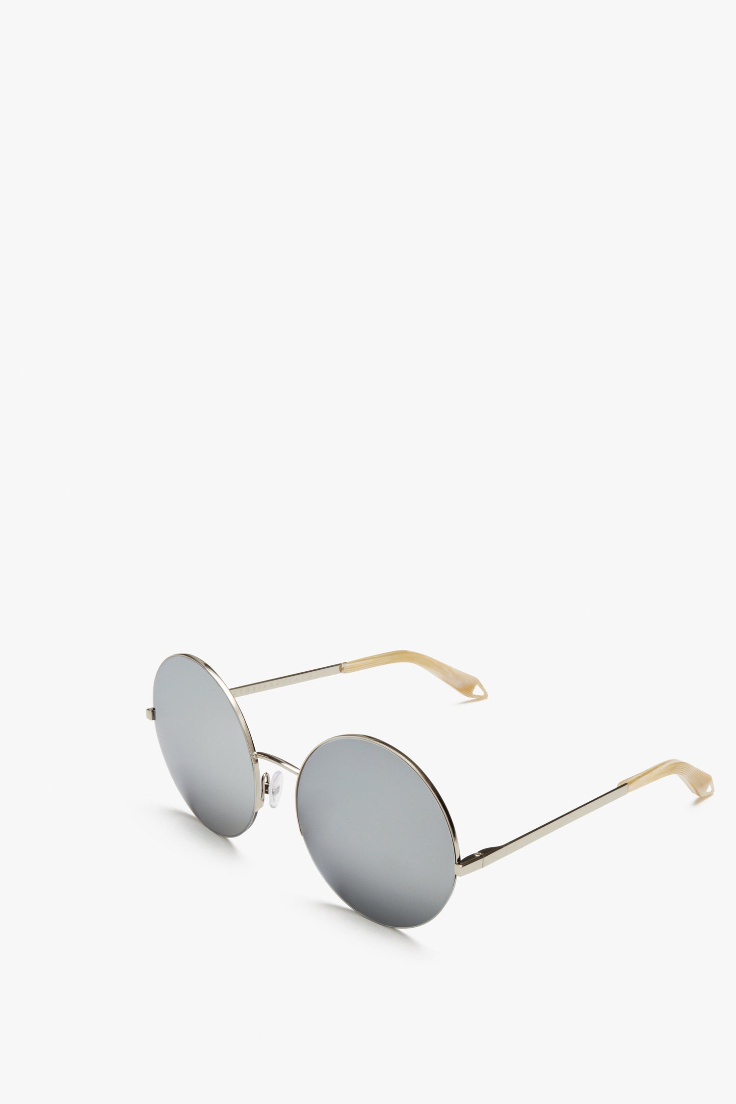 A pair of Supra Round sunglasses by Victoria Beckham with silver frames and light brown temple tips, featuring Zeiss certified lenses for superior UV protection, displayed on a white background.