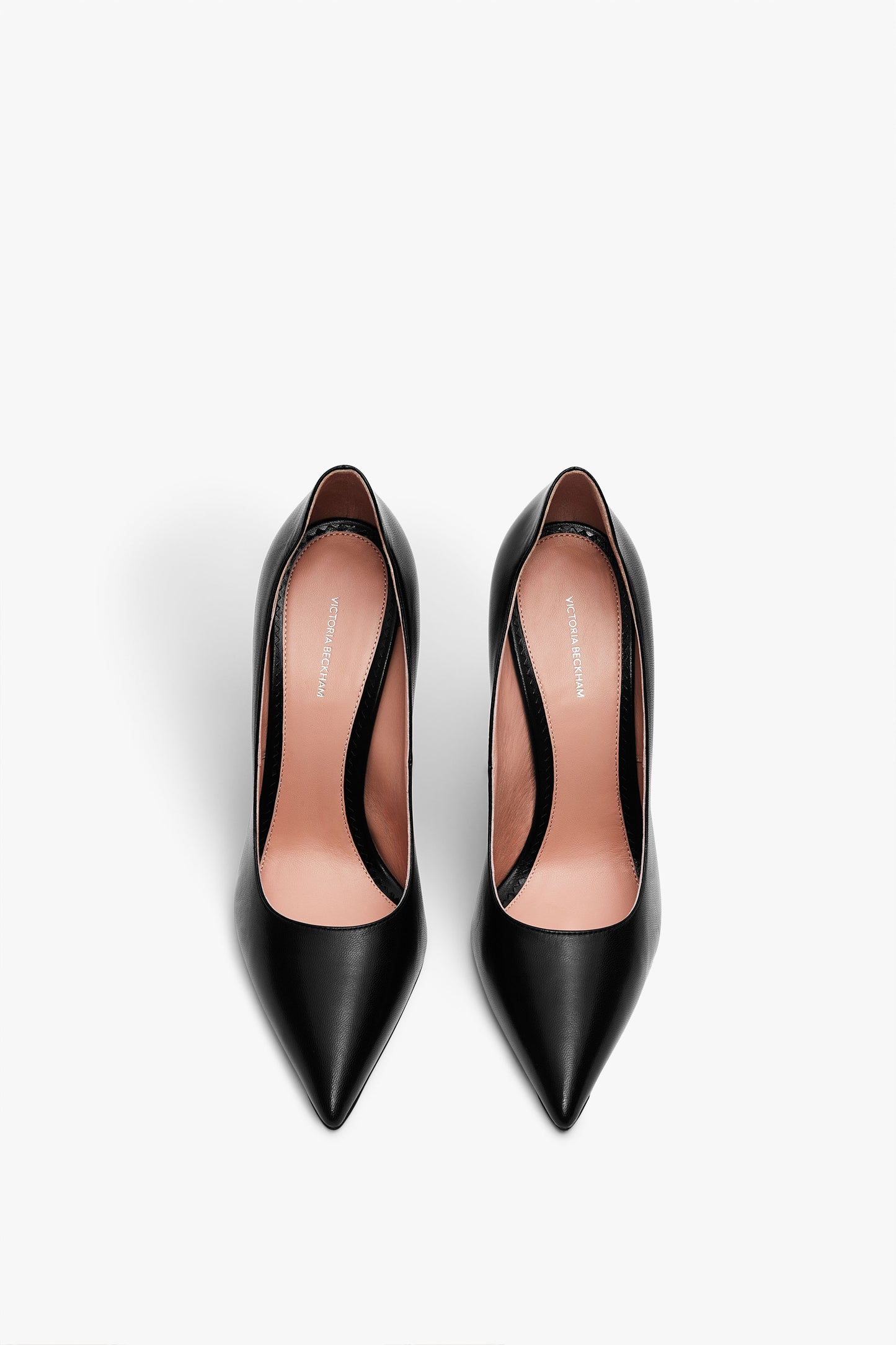 A pair of Victoria Beckham VB Pump 115mm in Black viewed from above, showcasing their pointed toes and classic stiletto heel design.