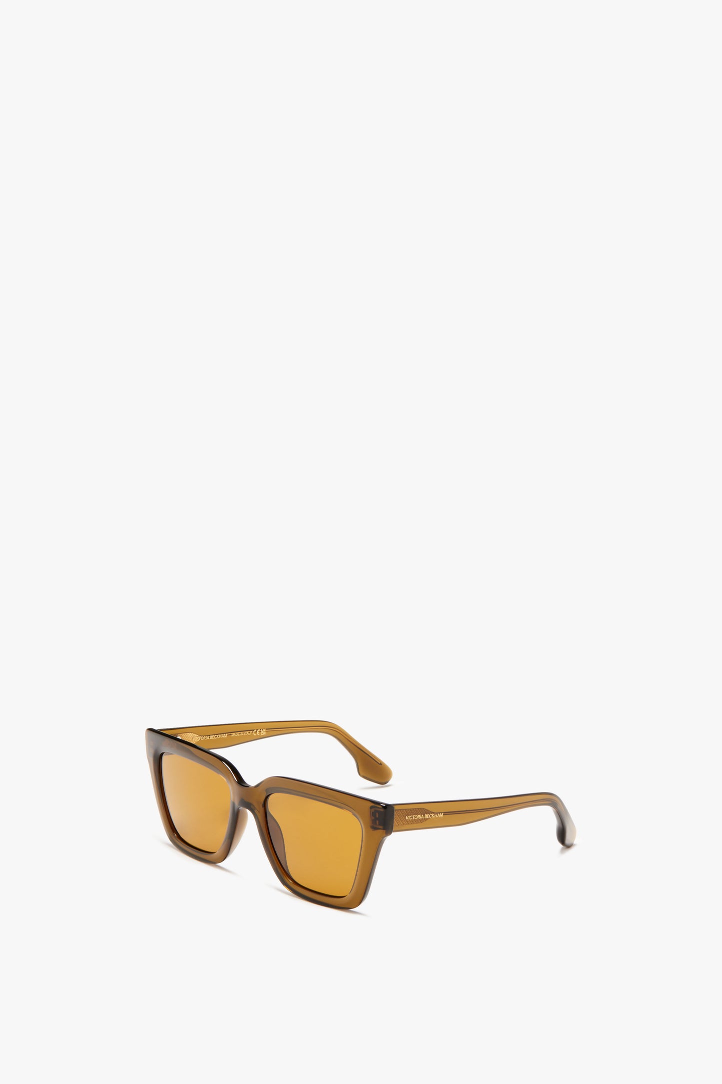 Victoria Beckham's Crystal Frame Sunglasses In Khaki, featuring rectangular brown sunglasses with amber-tinted lenses, designed with slightly curved temples and crafted from clear khaki acetate, are positioned on a plain white background.
