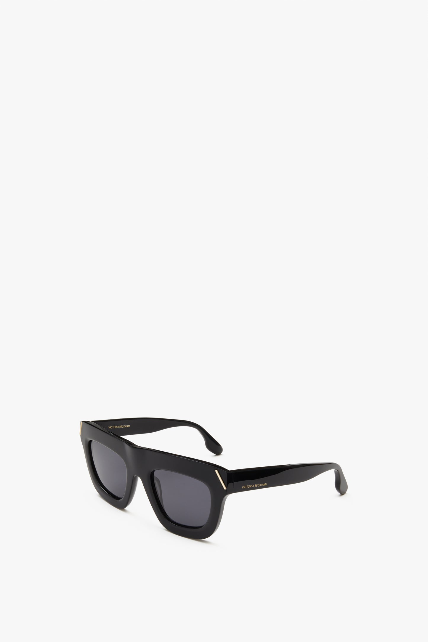 Wide oversized, square shaped sunglasses in black. These Victoria Beckham logo sunglasses have the VB logo on the temple and V shaped metal detailing on the hinges. Stylish and oversized yet in a classically vintage wide sunglass shape.